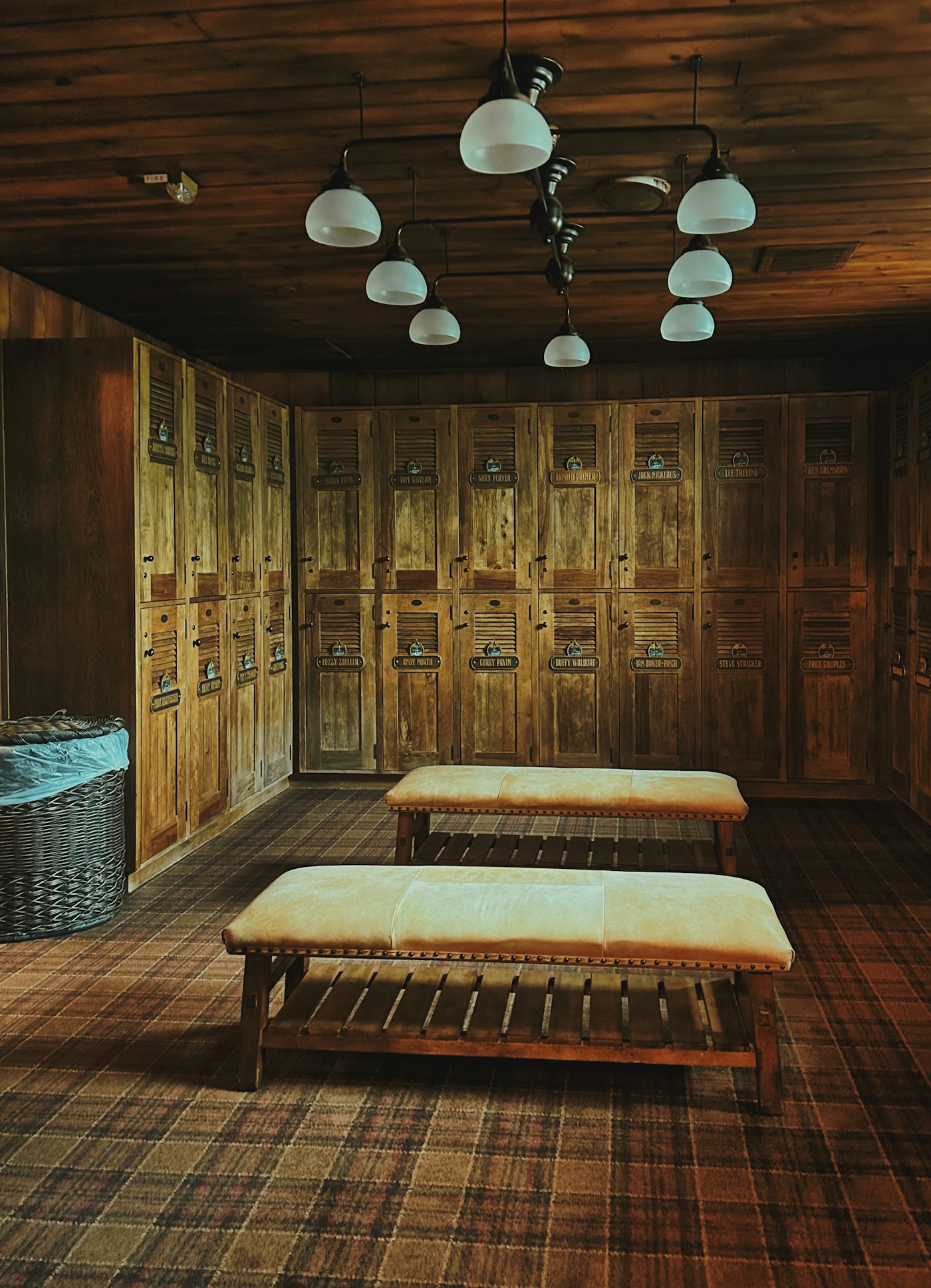 Wood-paneled members' locker room with leather benches